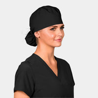 A woman wearing a solid black scrub hat, known as a Pony Scrub Cap, with a sleek and stylish look.