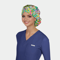 Woman wearing a colorful floral scrub cap and blue scrub top on a gray background