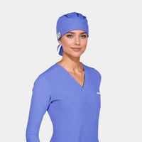 A person wearing a calypso blue scrub hat and matching scrubs against a white background.