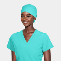 A person wearing a solid green surgical scrub cap and matching scrubs.