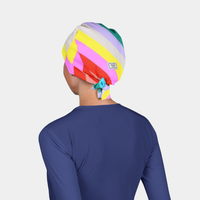 Person wearing a colorful striped scrub cap on a light gray background