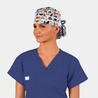 woman wearing a ponytail scrub hat that has various cats all over it and a navy blue scrub top