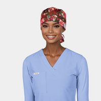 Person wearing a floral scrub cap and light blue scrub top on a plain background