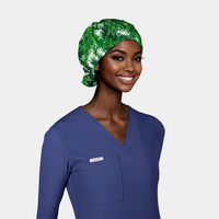 woman with a long sleeve navy scrub top on and a christmas surgical cap with green fir branches on a white background