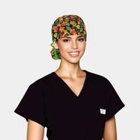 woman wearing a ponytail scrub cap with colorful autumn leaves on a black background and also wearing a black scrub ttop