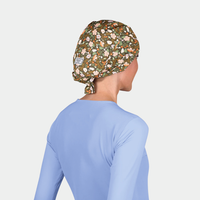 woman wearing a light blue scrub to pand a scrub hat that has flowers in neutral colors