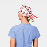 Person wearing a valentines scrub cap with a red band on a plain background
