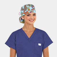 woman wearing a navy scrub top and a ponytail scrub cap that is light blue with flowers, butterflies and plants on it.