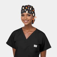 Woman wearing a black scrub top and a Halloween-themed ponytail scrub cap on a white background