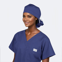A person wearing a navy blue scrub hat with a ponytail style, matching with navy blue scrubs.