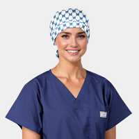 Person wearing a blue scrub top and patterned scrub cap on a white background