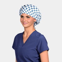 Woman wearing a blue scrub top and patterned headscarf on a white background
