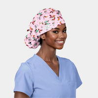 woman wearing a light blue scrub top and a pink bouffant hat with dogs on it on a white background