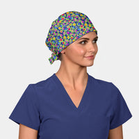 Woman wearing a colorful patterned scrub cap and blue scrub top on a white background