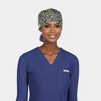 woman wearing a blue scrub top and a floral scrub cap on a white background