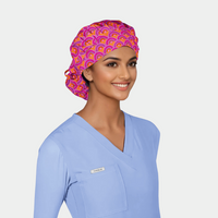 woman wearing blue scrubs and pink and orange scrub hat in an abstract pattern