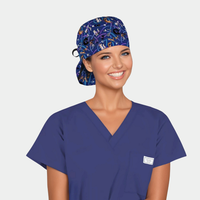 Person wearing a blue scrub top and scrub cap with cats on it and on a light gray background