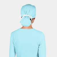 Person wearing a light blue surgical cap on a plain background