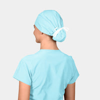 A person viewed from the back wearing a blue scrub cap tied with a white ribbon bow on top.