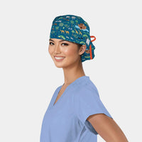 Person wearing a blue scrub top and a colorful scrub cap with animals on it on a white background