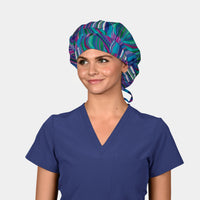 Woman wearing a blue scrub top and colorful patterned scrub cap on a white background