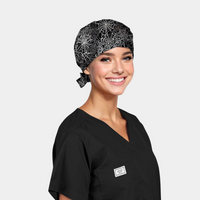 a woman wearing a black scrub top and a halloween scrub hat that is black with white spiderwebs