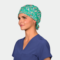 woman wearing a navy blue scrub top and a green christmas hat with red candies on it