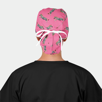 woman wearing a black scrub top and a pink ponytail scrub cap with zebras on it