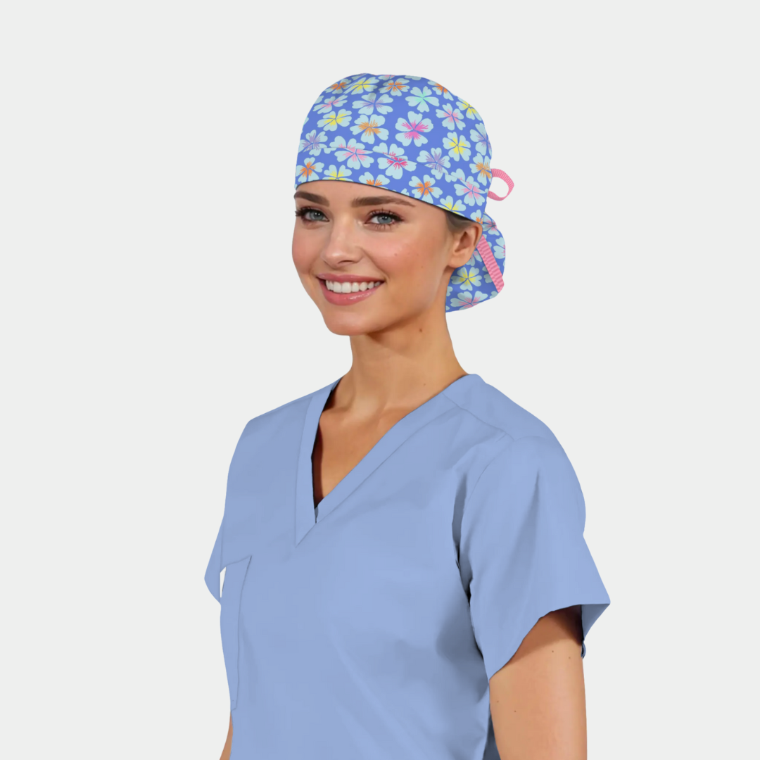 Person wearing a light blue scrub top and a colorful floral-patterned scrub cap on a white background
