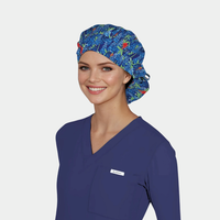 Person wearing a blue scrub top and blue floral scrub cap on a light gray background