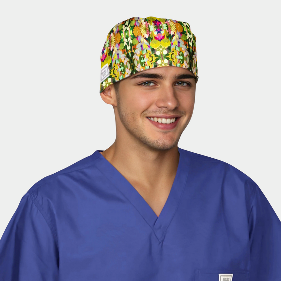 man wearing a navy blue scrub top with a scrub hat that has green and colorful vines on it on a white background