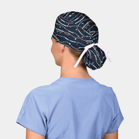 Person wearing a navy scrub cap with colorful patterns and a light blue scrub top on a light gray background.