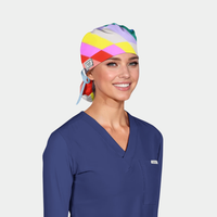 Person wearing a colorful scrub cap and blue scrub top on a light gray background