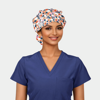 woman wearing a floral bouffant scrub hat with small navy, orange and red flowers and a navy blue scrub top
