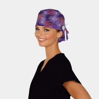 woman wearing a black scrub top with a purple ponytail scrub cap that has spiderwebs all over