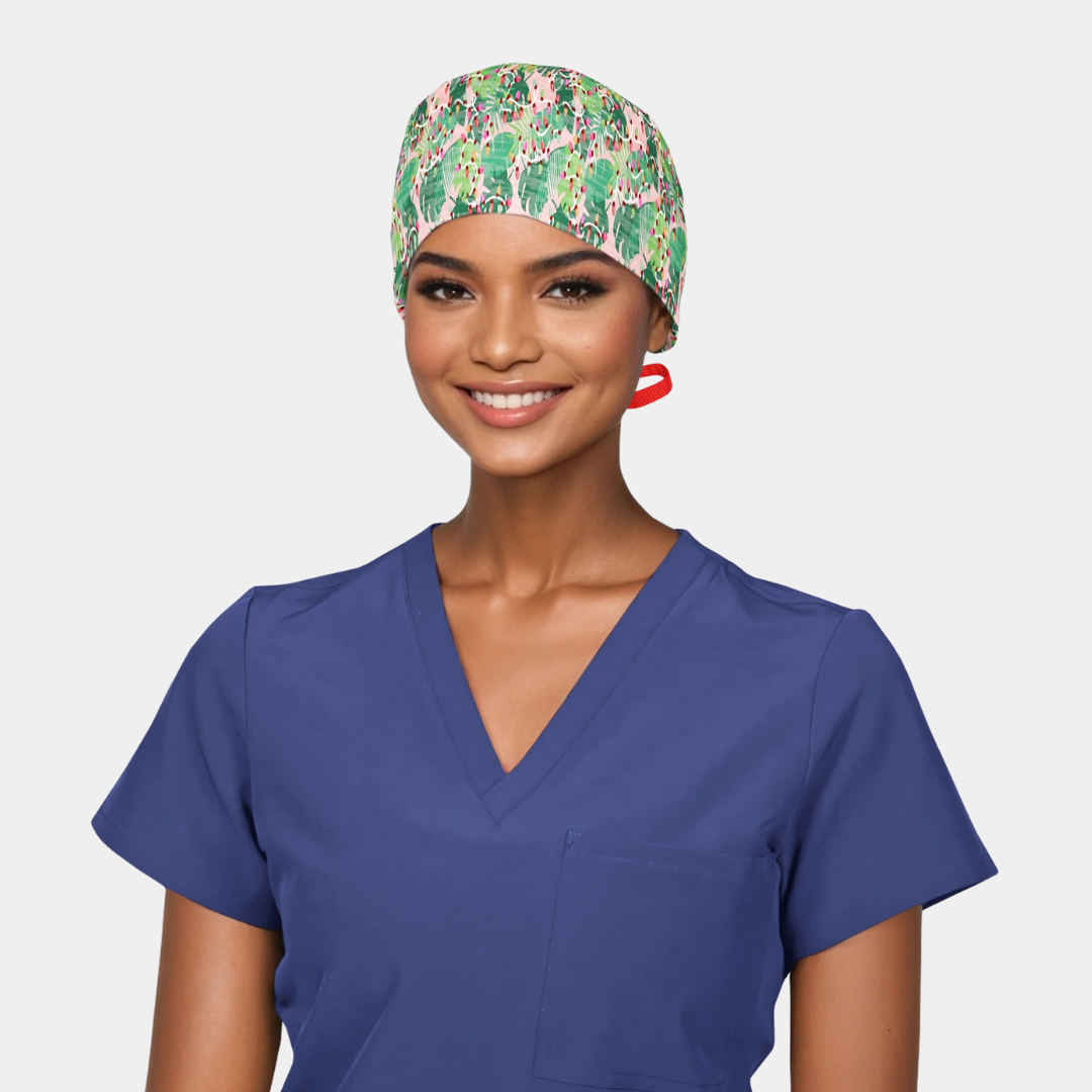 woman wearing a navy blue scrub top and a christmas surgical cap that is pink wit green palm leaves and a red ribbon