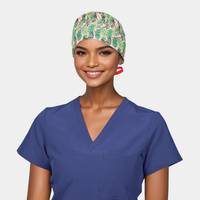 woman wearing a navy blue scrub top and a christmas surgical cap that is pink wit green palm leaves and a red ribbon