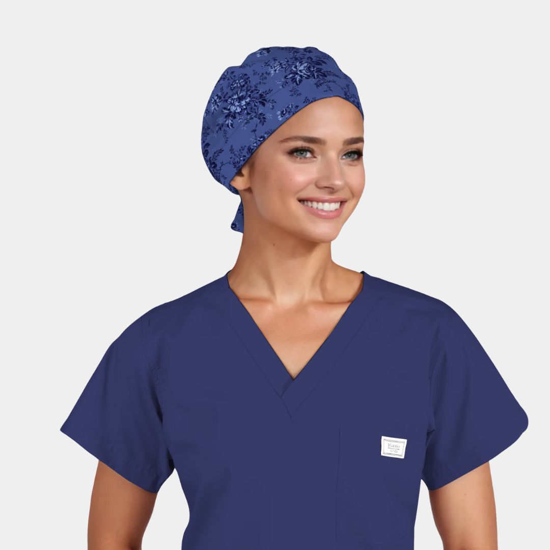 Woman wearing a blue scrub top and blue scrub cap on a white background