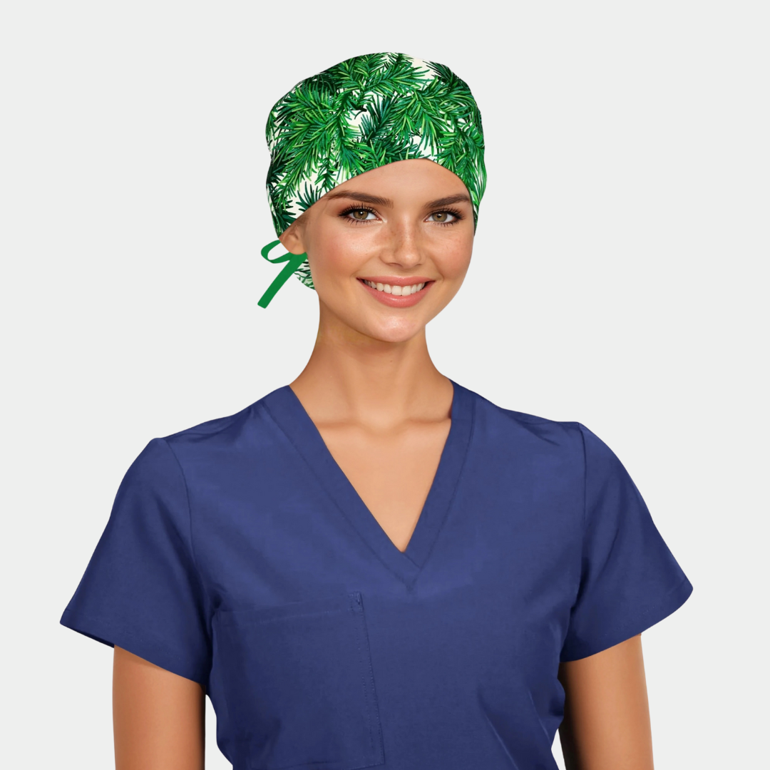 a woman with a navy scrub top on and a christmas themed scrub hat with green fir branches on a white background