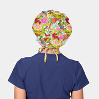 person wearing navy blue scrubs and a colorful bouffant hat with birds and flowers and tress on a light blue background
