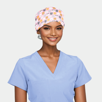 person wearing a light blue scrub top and a pink scrub hat with cute cats on it
