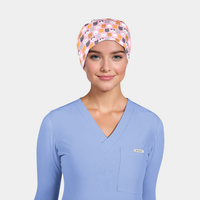 woman wearing a light blue scrub top with a pink scrub hat that has cats on it