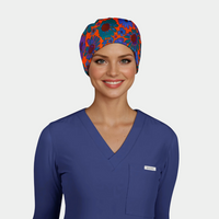 woman wearing a navy long sleeved scrub top and a scrub cap that is orange with bright green and blue flowers