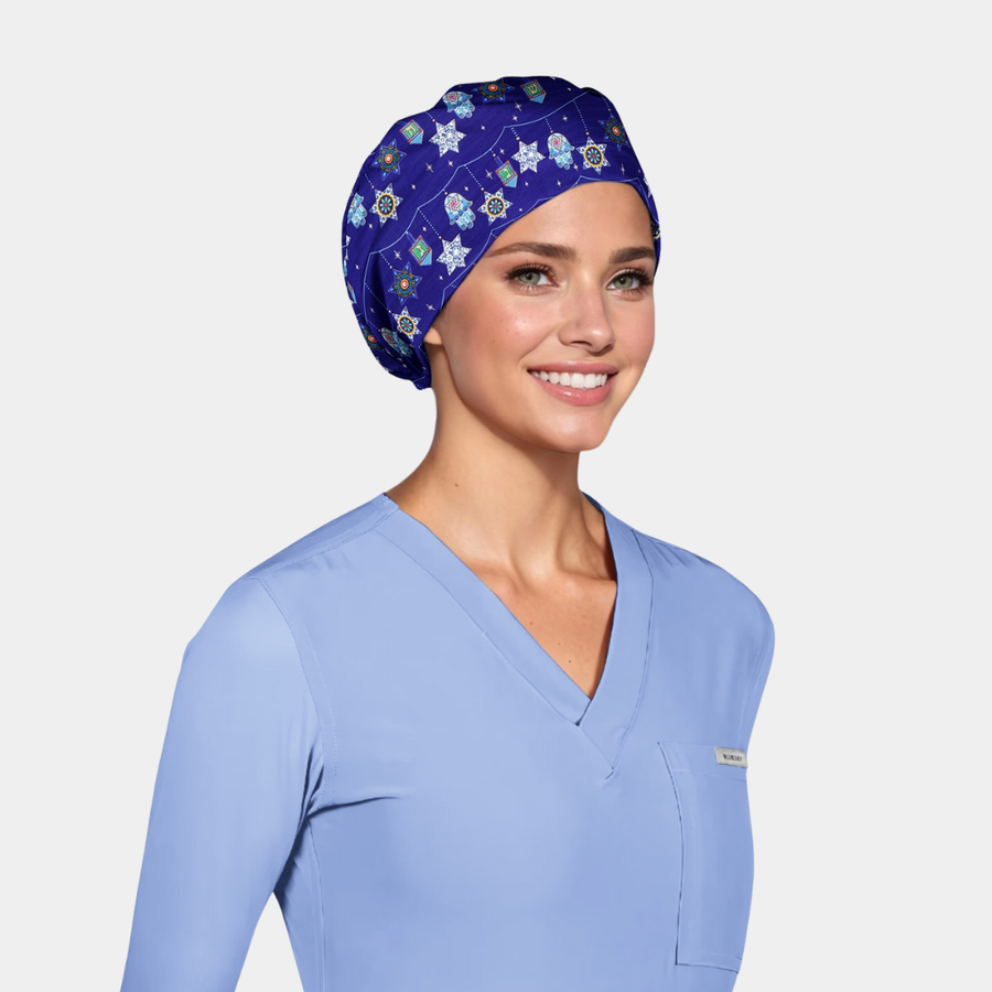 Woman wearing a light blue scrub top and a hanukkah scrub cap on a light gray background