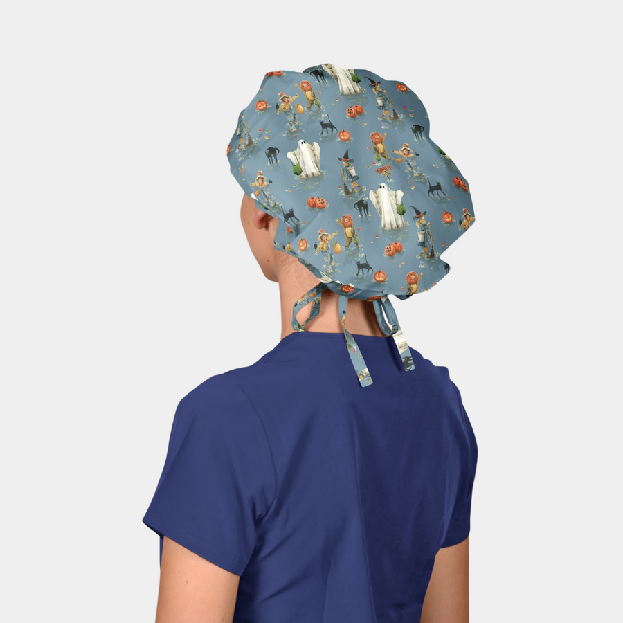 woman wearing a halloween bouffant scrub cap that is blue with ghosts, cats and pumpkins on it