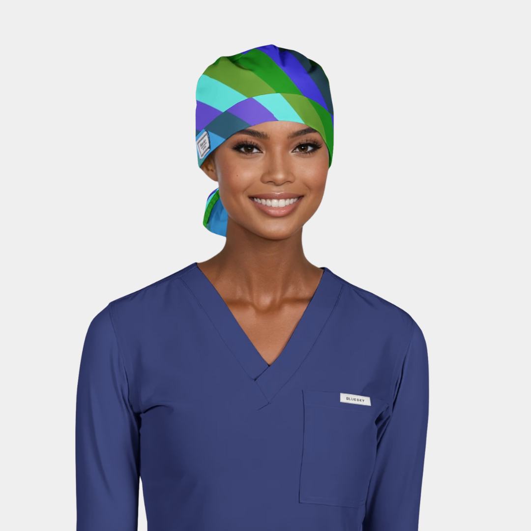 Person wearing a colorful scrub cap and blue scrub top on a light gray background