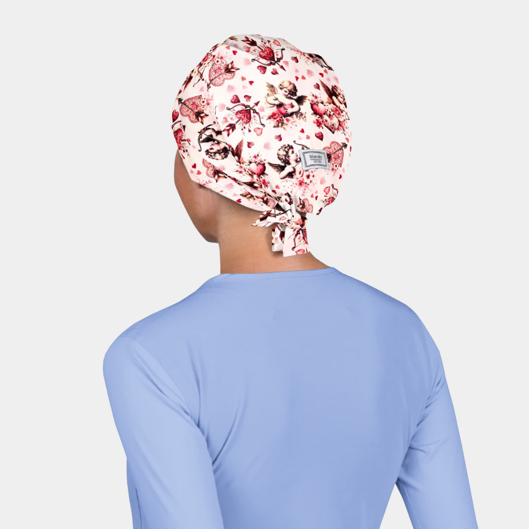 Person wearing a floral-patterned scrub cap on a plain background
