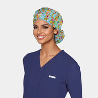 Woman wearing a blue scrub top and floral scrub cap on a plain background