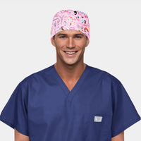 man wearing a navy blue scrub top and a pink scrub hat with parisian symbols on it