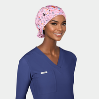 woman wearing a navy blue scrub top and a pink scrub hat with eiffel towers and other parisian icons on it